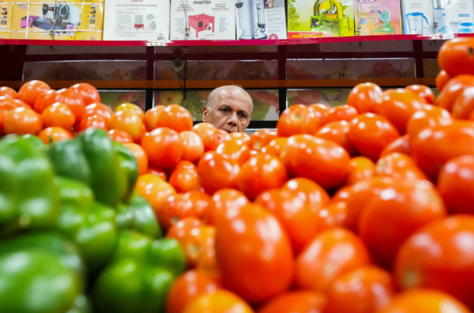 A man selects fresh tomatoes at a Brampton, Ont. grocery store, on Nov. 1.