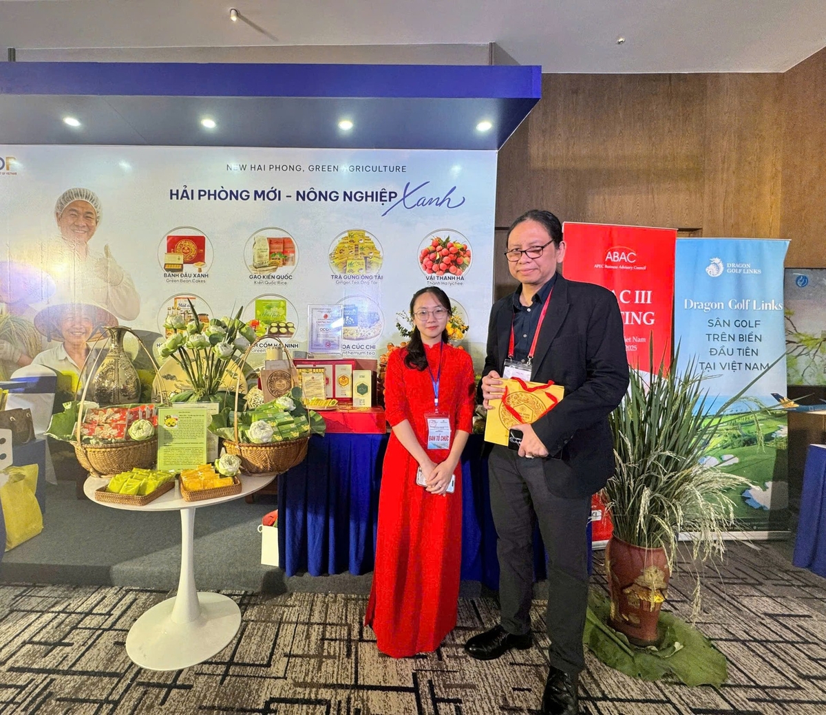 A foreign delegate takes a souvenir photo after purchasing Hai Phong’s agricultural products as gifts. Photo: Dinh Muoi.