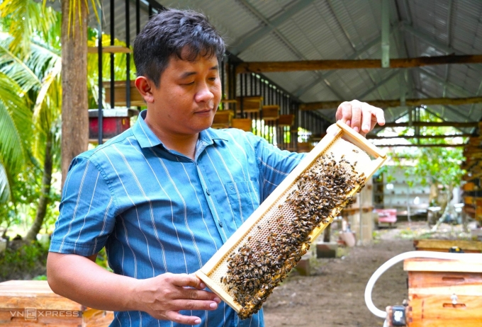 Mr. Nguyen Minh Tung and a bee bridge containing honey. Photo: An Minh