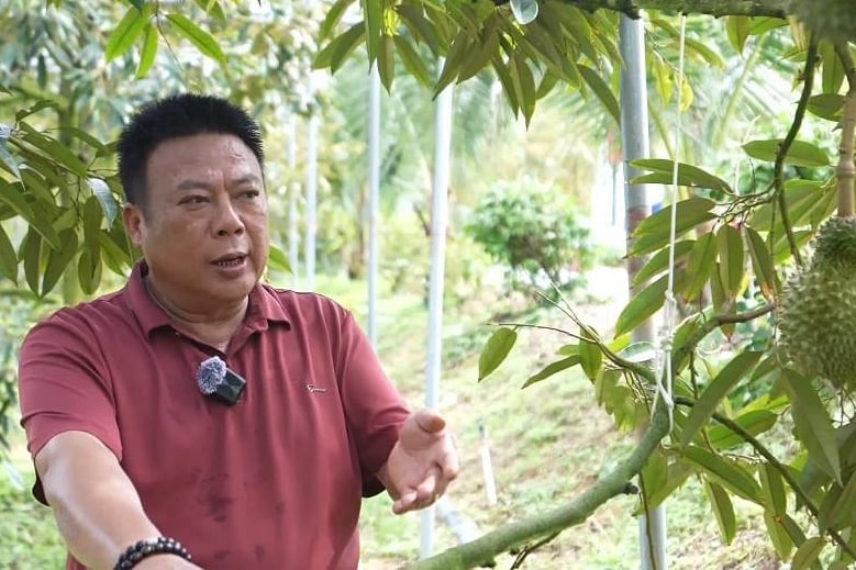 Farmer Deng Qichang is delighted with the tree‑ripened durians grown on Hainan Island. Photo: Xinhua.