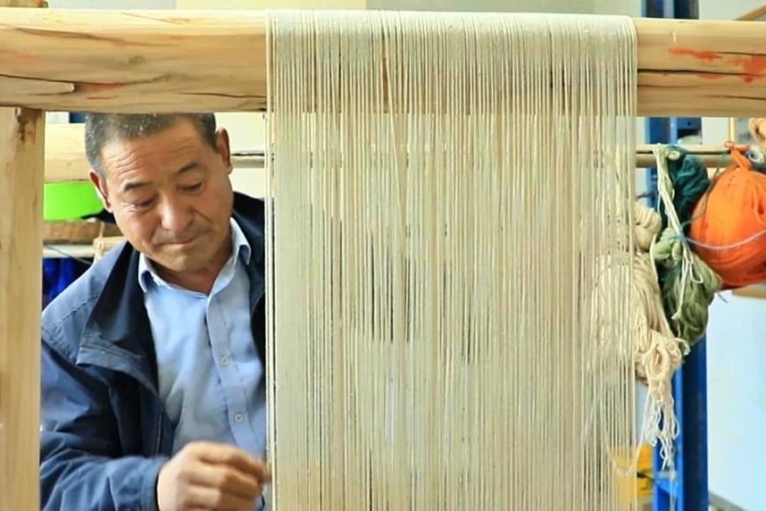 Duyang Yongliang at the carpet weaving loom in Qinghai Province. Photo: Xinhua.