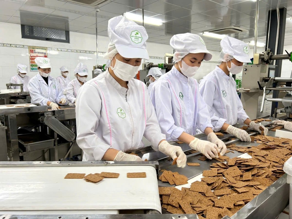 The production line at My Phuong Food is busy filling roasted coconut cake export orders.