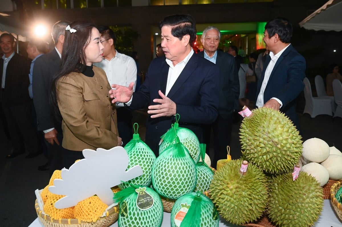 Ngo Tuong Vy, General Director of Chanh Thu Group, discusses products with former Deputy Minister of Agriculture and Environment Le Quoc Doanh at the exhibition celebrating the sector's 80-year tradition. Photo: Tung Dinh.